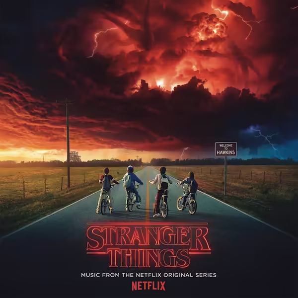 Four kids on a road with their bikes stare at the monster in the dark clouds.