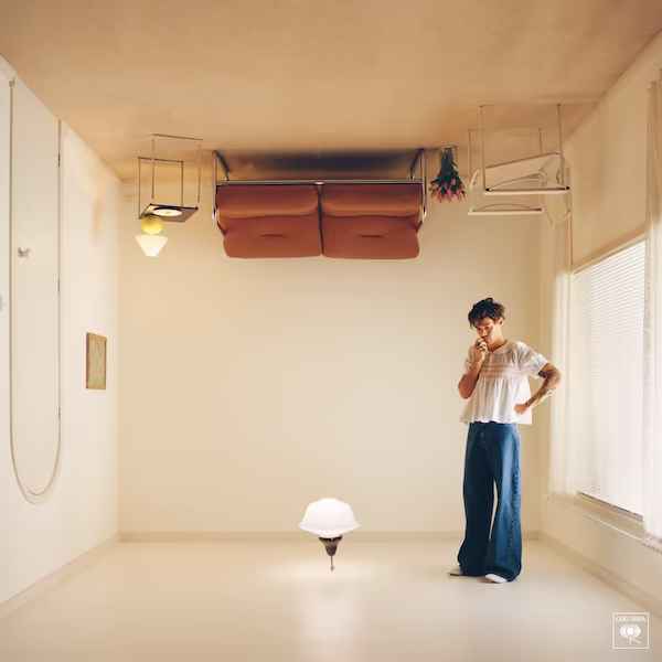 Styles stands on the ceiling of an upside-down furnished room.