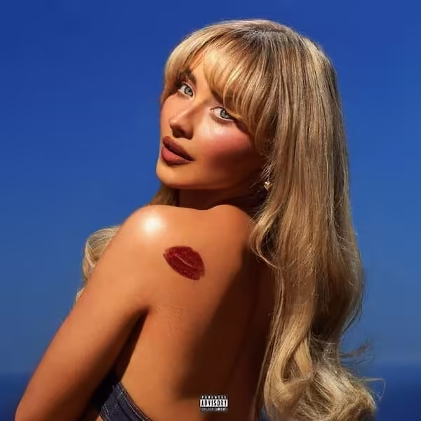 Carpenter looks back over her shoulder at the camera with a lipstick mark on her shoulder.